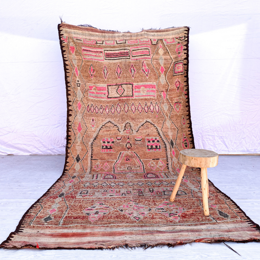Full view of a peach and pink patterned handwoven wool Boujaad Moroccan rug.