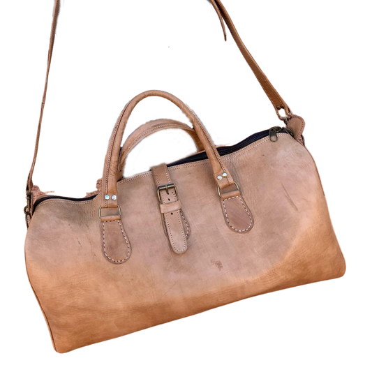 Handcrafted cow leather shoulder bag with a top handle, adjustable shoulder strap, and buckle closure.