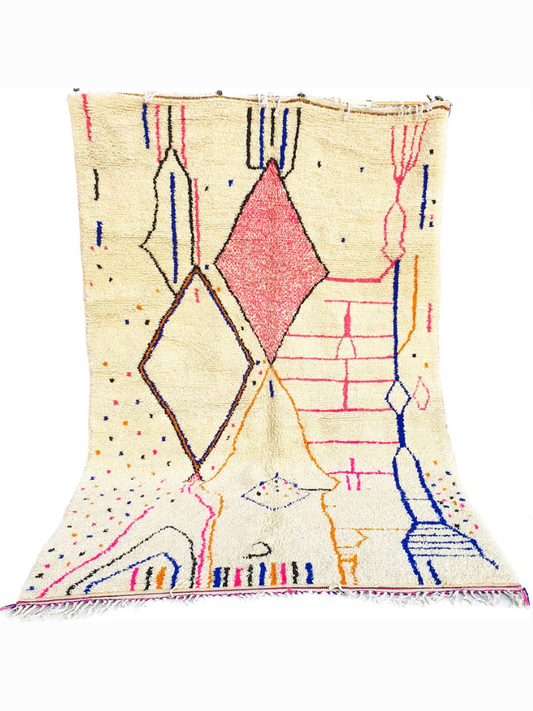 Full view of a handwoven geometric diamond Beni Ourain Moroccan rug with a bold pink diamond and other colorful geometric accents.